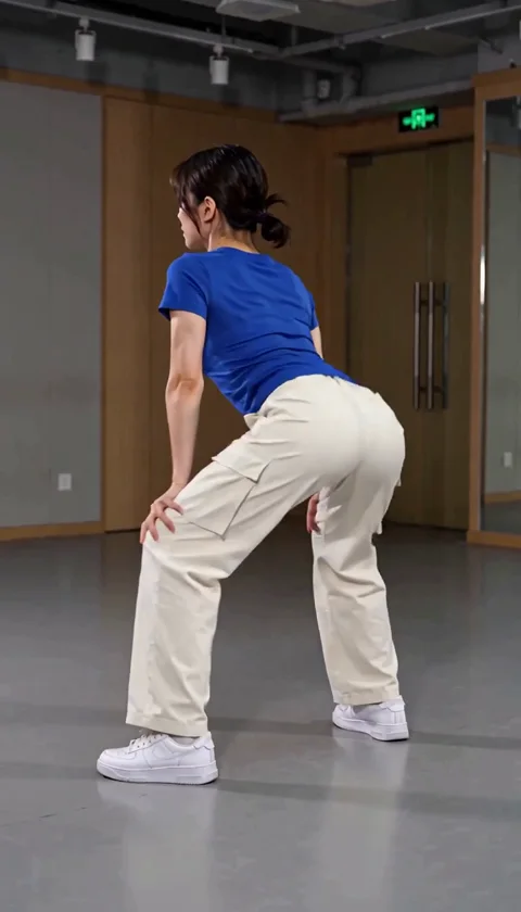 Verfolge die wiederholten Beckenimpulse und die Bewegung der Hose. Der Clip ist eine generierte Tanzinterpretation; prüfe Knie, Füße und Körperform während der ganzen Aufnahme. In diesem Ergebnis hat das Modell auch Frisur und Studio verändert. — In Bewegung